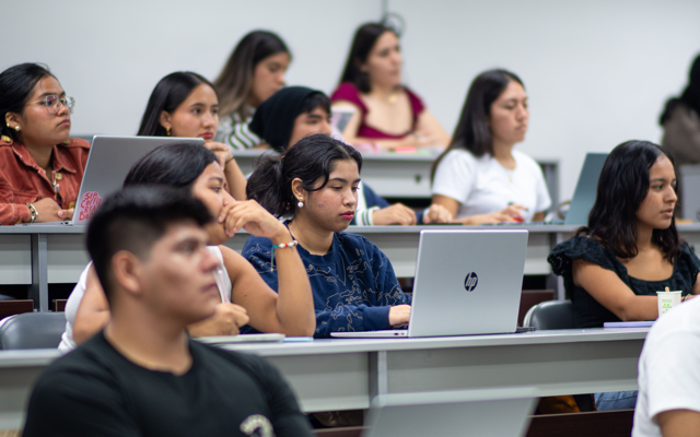 Aula universitaria llena de estudiantes en clase de Psicología