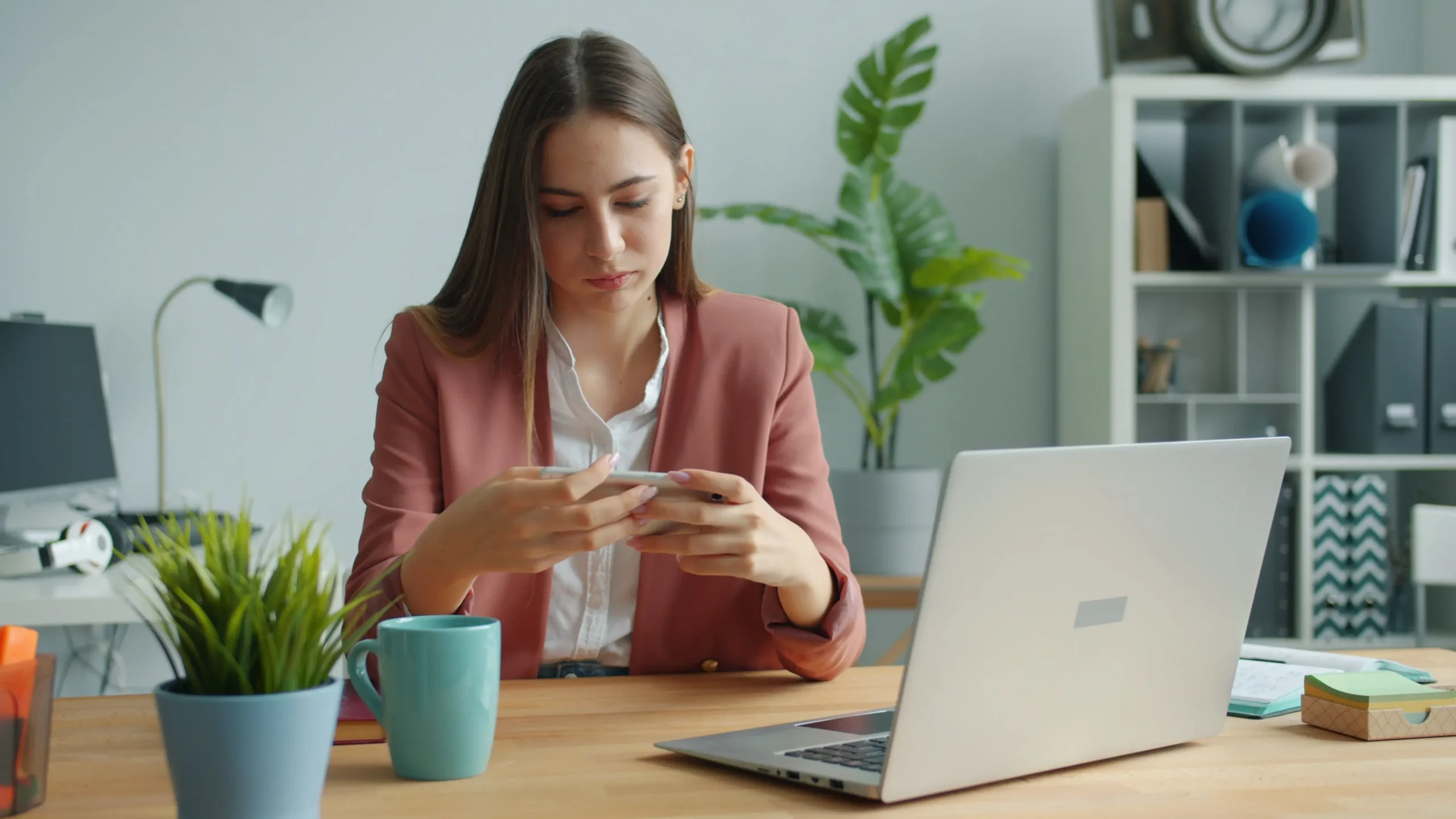 Joven revisa ofertas de empleo en su laptop sentado en una cafetería
