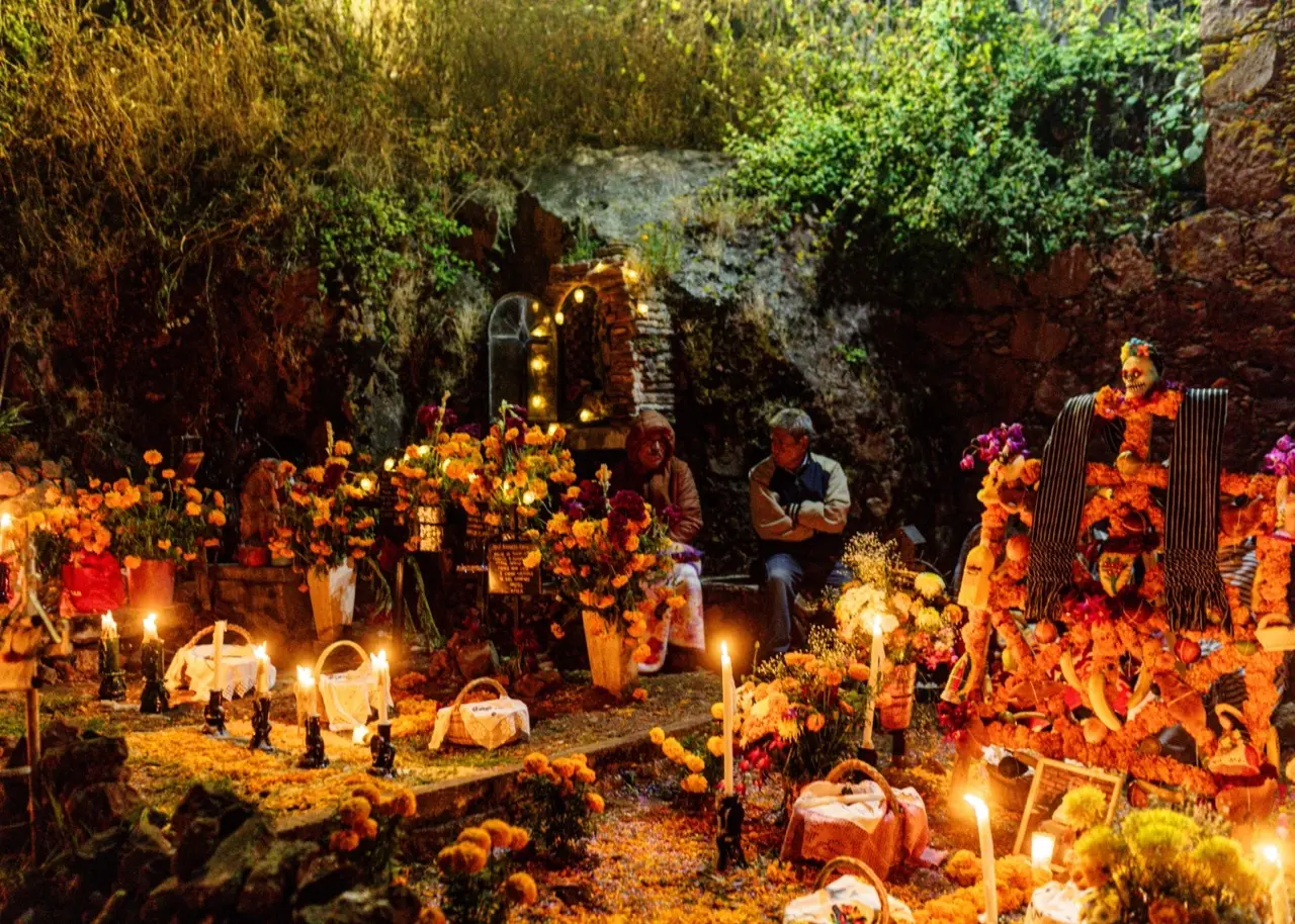 dia de muertos Velas encendidas y flores de cempasúchil sobre tumbas en un panteón de pueblo durante la noche de Día de Muertos.