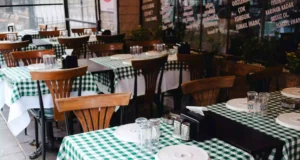 Salón de restaurante familiar con comensales en sobremesa y área de juegos infantiles al fondo