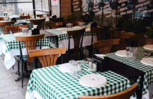 El piso de venta no perdona: por qué abrir una sucursal sin flujo garantizado devora el margen Salón de restaurante familiar con comensales en sobremesa y área de juegos infantiles al fondo